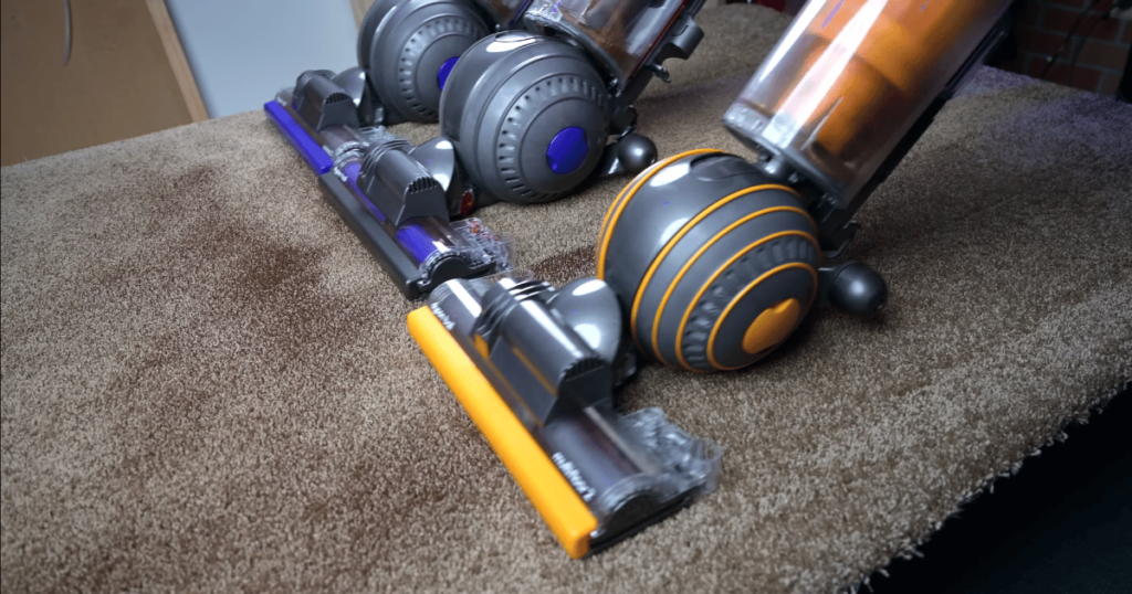 Three Upright Vacuums on Carpet