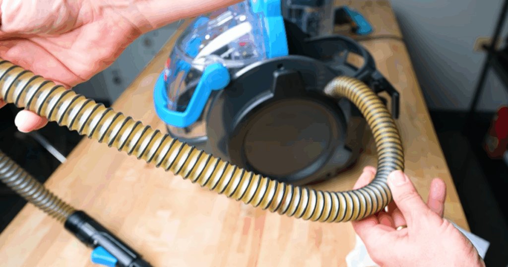 Close-up of a portable carpet cleaner hose that was not cleaned for over a year, showing residue buildup inside the tube during Vacuum Wars self-cleaning tests.