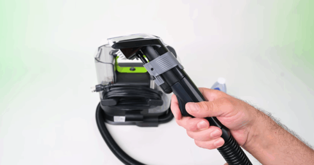 Vacuum Wars demonstrating a portable carpet cleaner handle with a button that stops water flow through the hose, showing an alternative self-cleaning method used to flush residue from the line.