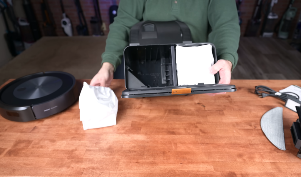 A person demonstrating the easy bag replacement process for the Roomba Combo j5+ Clean Base.