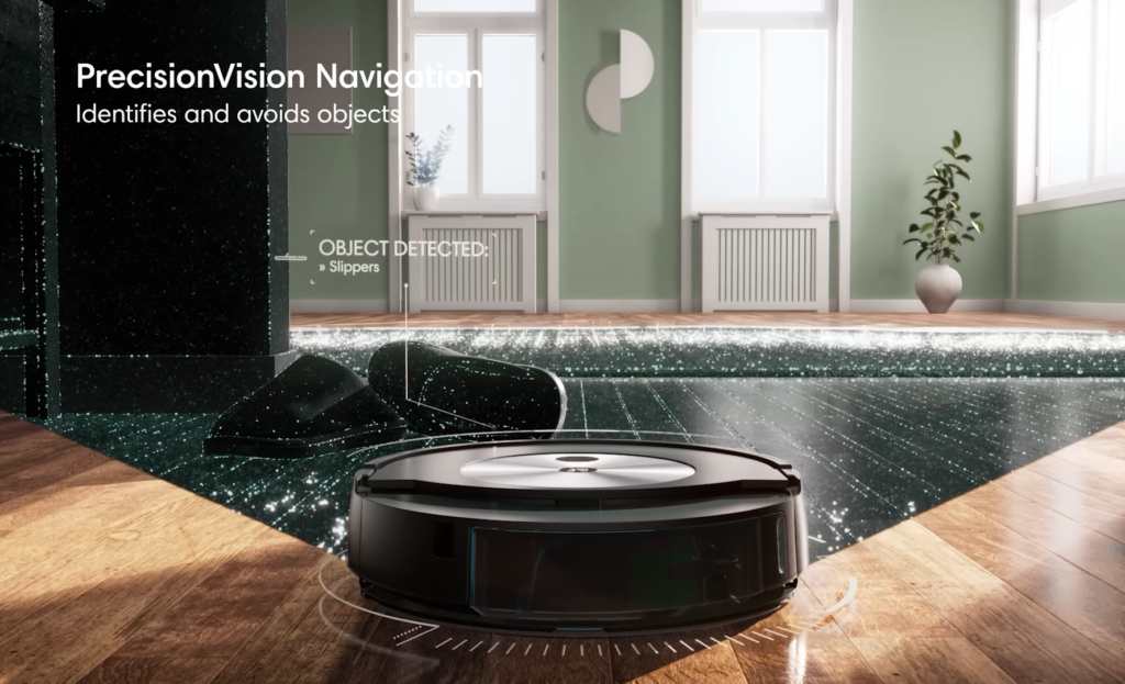 A Roomba j5+ robot vacuum on a wooden floor demonstrating its PrecisionVision Navigation.
