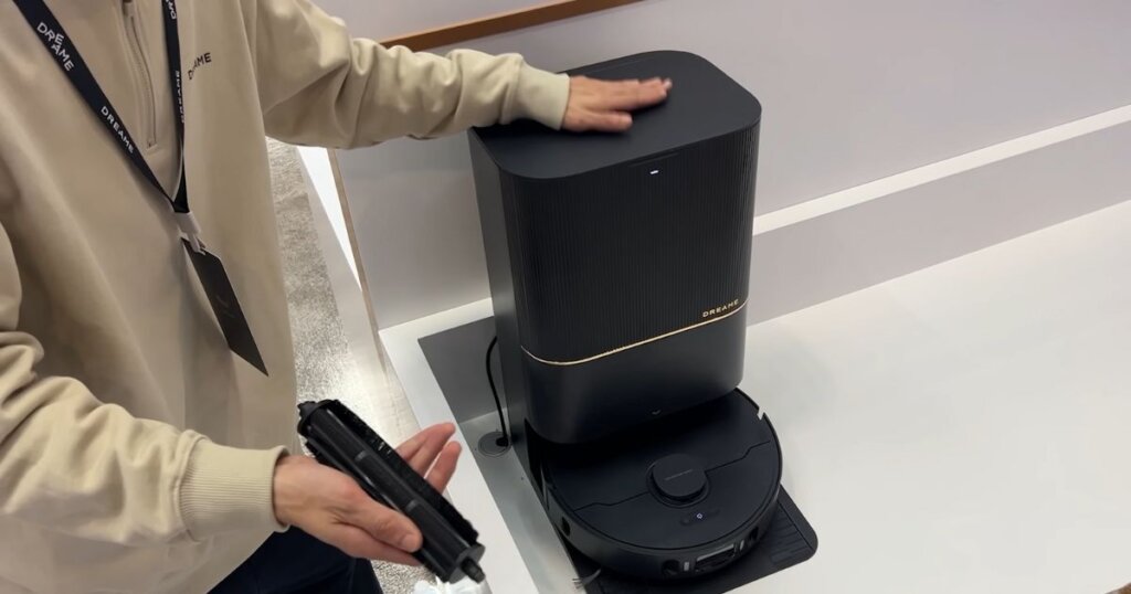 Person demonstrating the Dreame X30 Ultra’s dock and detachable brush roll for cleaning or replacement.