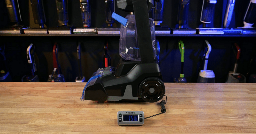 Carpet cleaner placed on a digital scale to measure total machine weight during ergonomics testing.