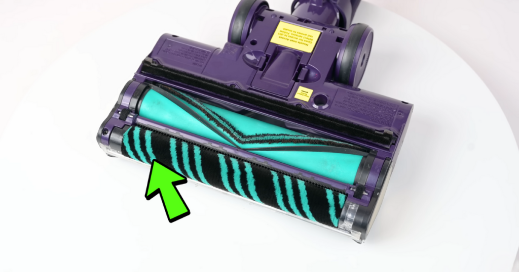 Close-up of the Shark PowerDetect vacuum's DuoClean roller system. The soft front roller and traditional back roller are visible, with a green arrow pointing to the front roller, highlighting its design.