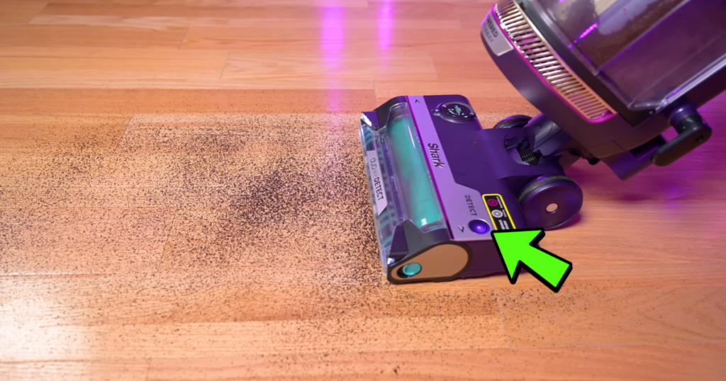 The Shark PowerDetect vacuum is shown in action on a hardwood floor, with a green arrow pointing to the Dirt Detect indicator. The vacuum is effectively picking up dirt and debris.