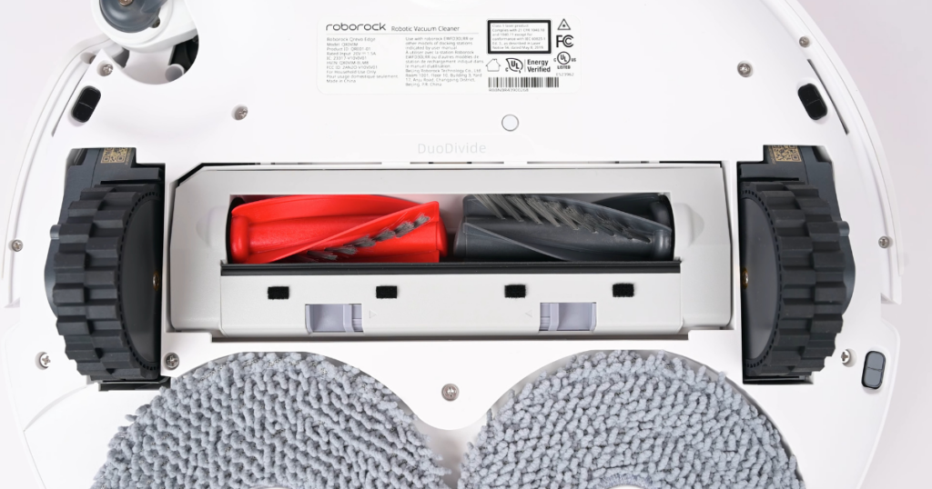 A close-up image of the Roborock QRevo Edge’s underside highlighting the DuoDivide brush roll. The red and gray dual brush system is visible, with mop pads positioned behind the brush roll.