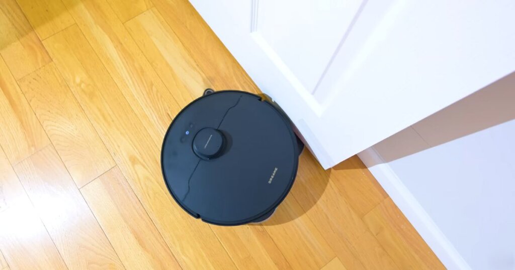 Dreame X40 Master shown reaching tight corners with its mop pad extended, demonstrating enhanced edge mopping coverage.