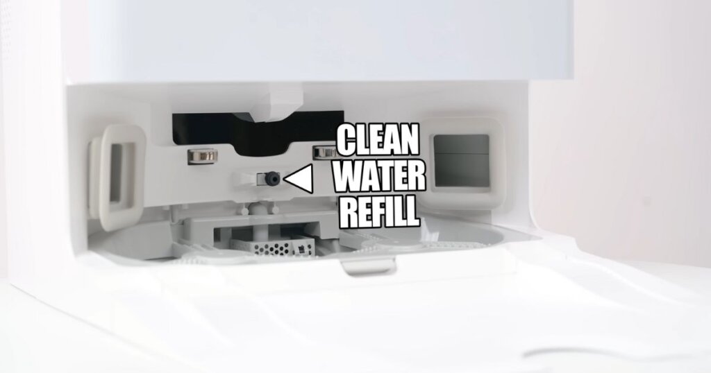 A close-up view of the Roborock QRevo Edge’s clean water refill port inside the docking station. A label points to the refill nozzle, indicating where clean water is dispensed for mopping.