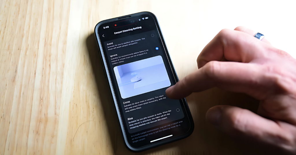 A hand using a robot vacuum app.