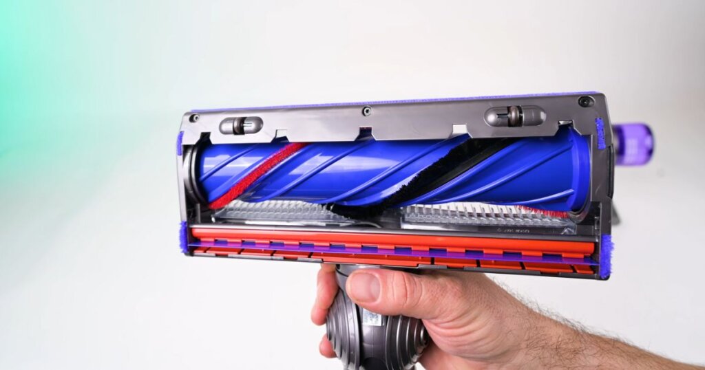 Close-up of the redesigned Motorbar cleaner head from the Dyson Digital Slim, featuring angled bristles and red/blue brushroll components.
