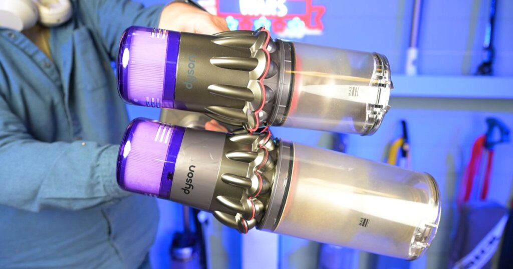 Side-by-side comparison of two Dyson cordless vacuums, both held horizontally to showcase differences in size and dustbin capacity.