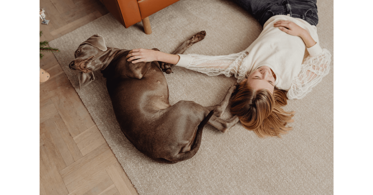 a dog and woman on a carpet,