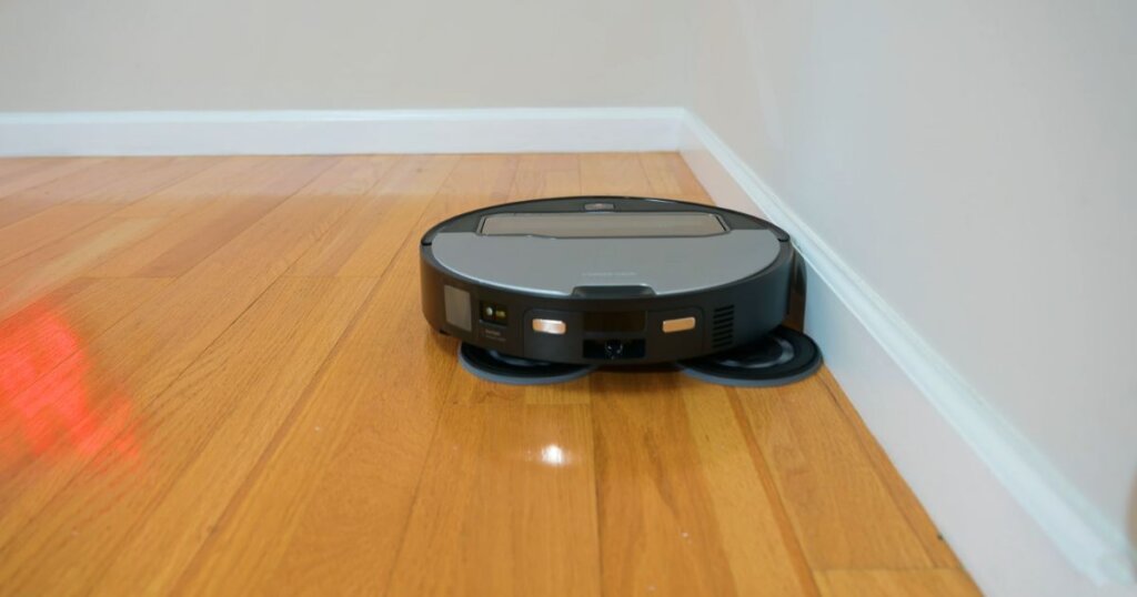 Roborock Z70 shown using its extended mop pads against a wall edge for improved cleaning coverage.