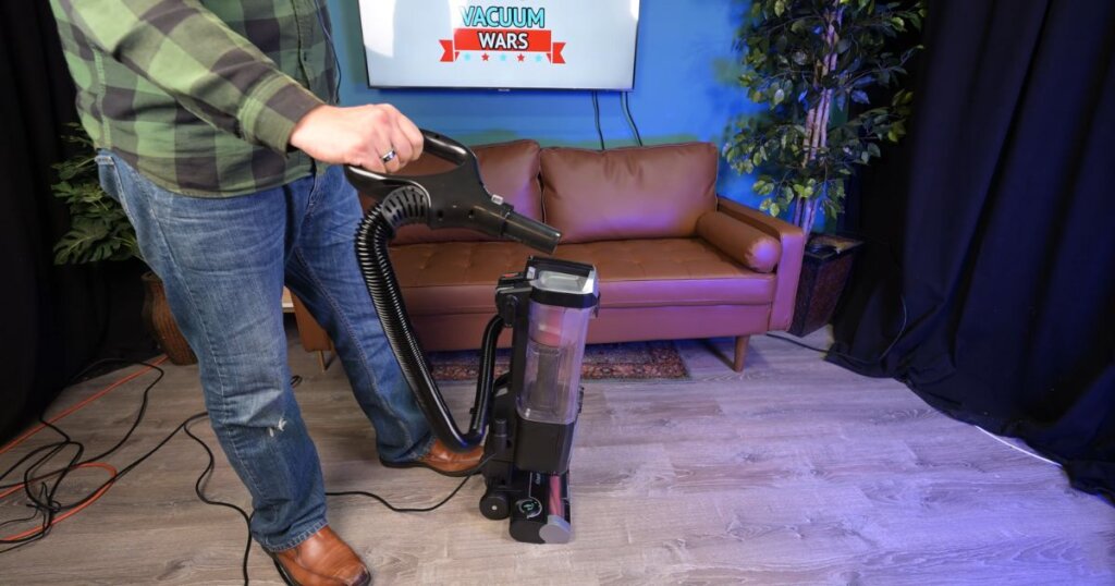 Person holding upright vacuum hose extended from the Shark Rotator Pet ZU102.