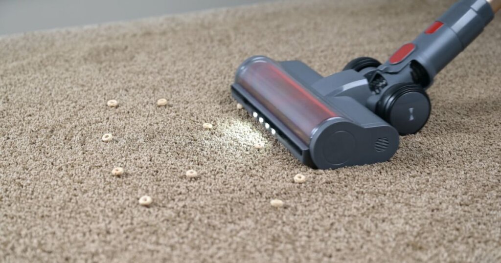 Smoture VAC01 vacuum head shown cleaning cereal debris from a carpet surface.