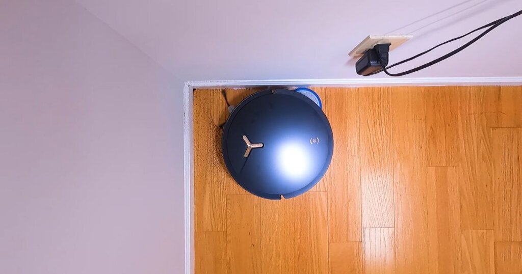 Overhead shot of the T50 Max Pro Omni robot vacuum navigating a tight corner, showing its side brush and mop pad cleaning along the wall edge.