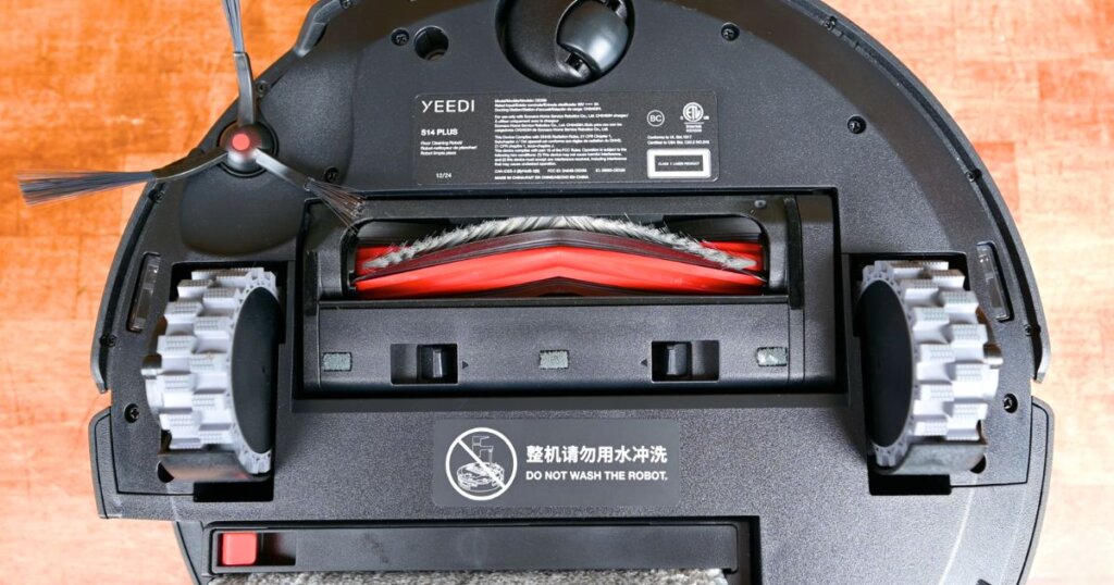 Close-up of the Yeedi S14 Plus main brush, showing the combination of bristles and rubber fins on the underside of the robot vacuum.