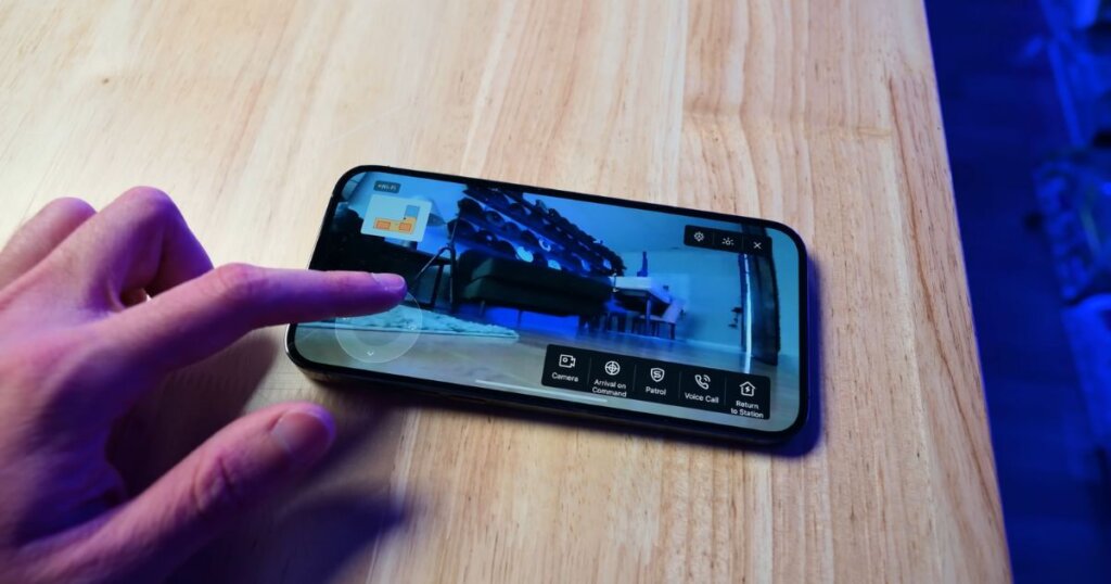 A person interacting with the Ecovacs mobile app on a smartphone, showing camera feed and various controls like Patrol, Return to Station, and Voice Call.