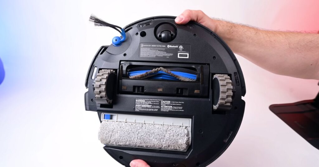 Underside view of the Ecovacs X9 Pro Omni showing its roller-style mop, single main brush, and one side brush.