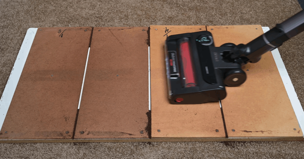 Shark Stratos cordless vacuum shown performing a crevice pickup test on a wooden board with carpet edges.
