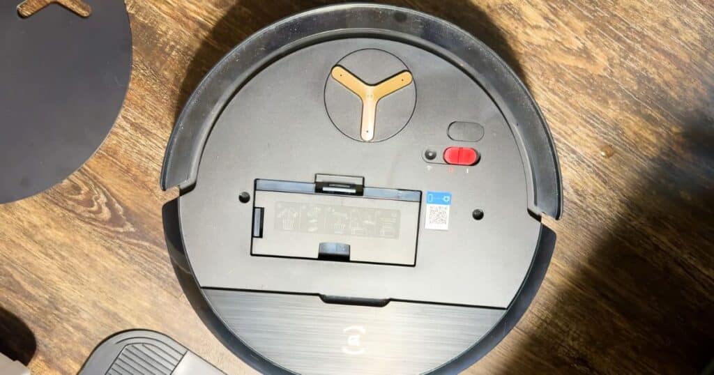 Ecovacs X9 Omni robot vacuum with top open, showing the power switch and reset button placement.