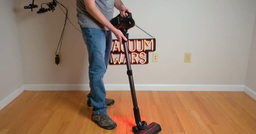 Person using the Eufy E20 cordless vacuum in handheld floor cleaning mode on hardwood.