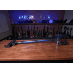 KARDV V06 in studio 150 ©Vacuum Wars | Vacuum Wars Row of vacuum tubes lined up on a wooden counter with a blue neon sign in the background reading 'VACUUM'.