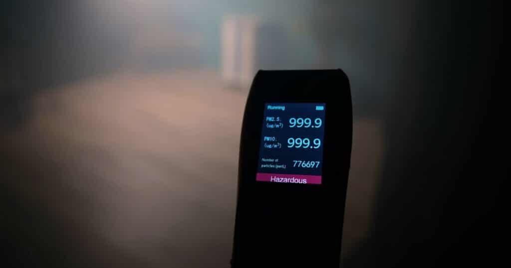 Air quality monitor displaying PM2.5 and PM10 levels during HEPA filter evaluation
