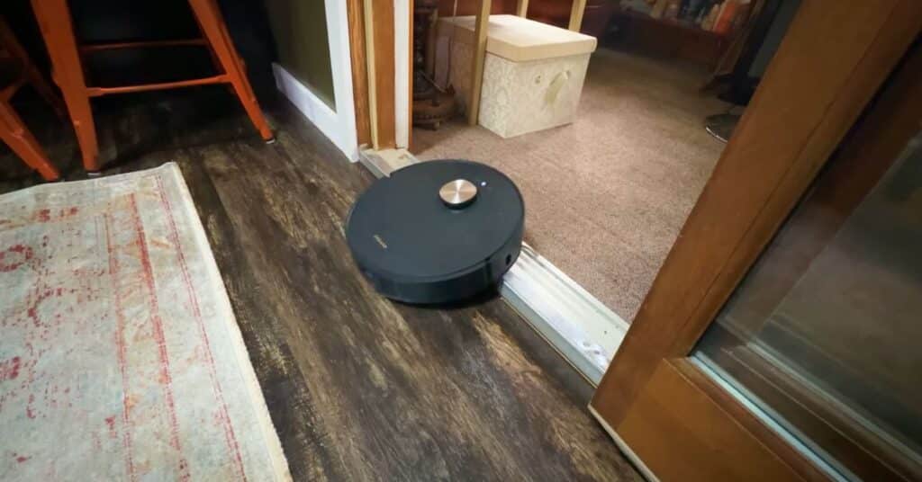 Dreame L50 Ultra robot vacuum climbing over a raised door threshold during testing.