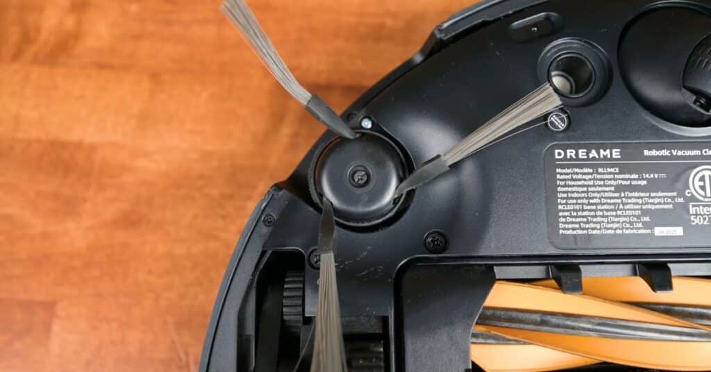 Close-up of Dreame L50 Ultra’s underside showing side brush with multiple gray bristles.