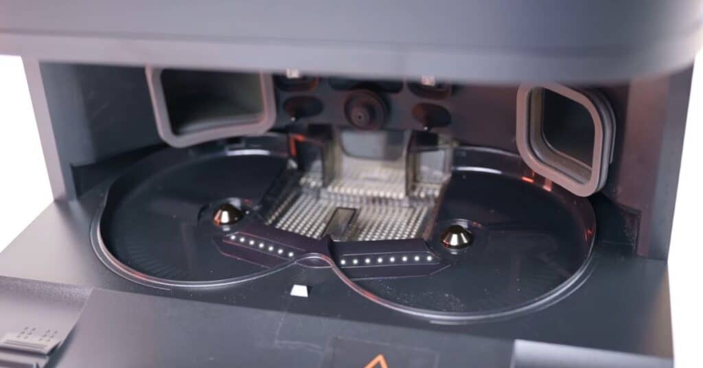 Close-up of Dreame L50 Ultra dock spray nozzle system with multiple water jets and washing area.