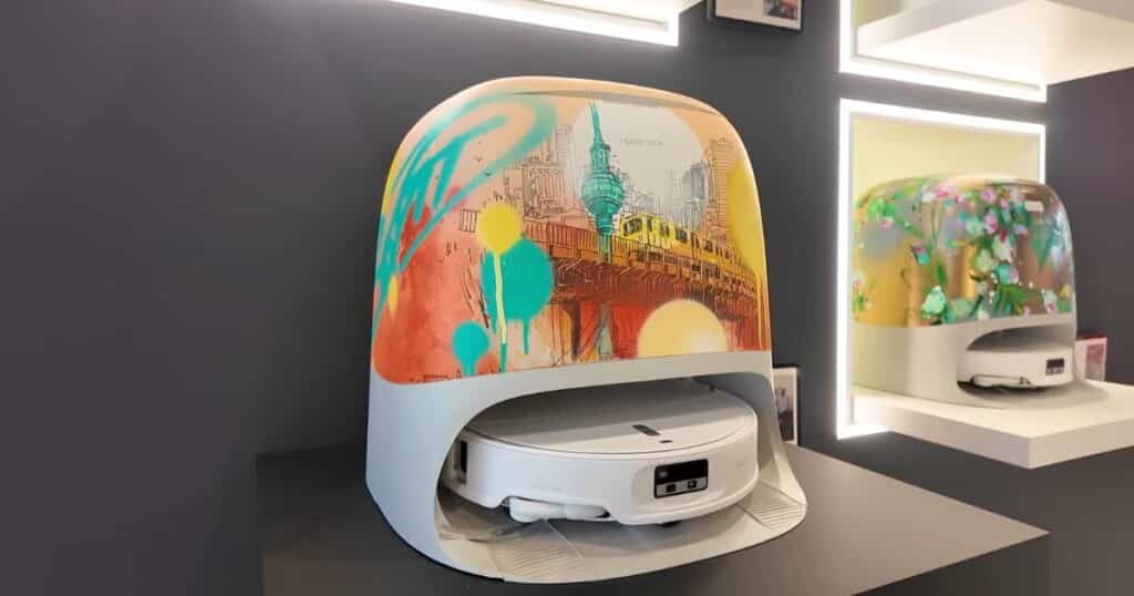 Roborock Curv 2 Pro robot vacuum base station at IFA 2025, decorated with a Berlin cityscape and graffiti-style artwork.