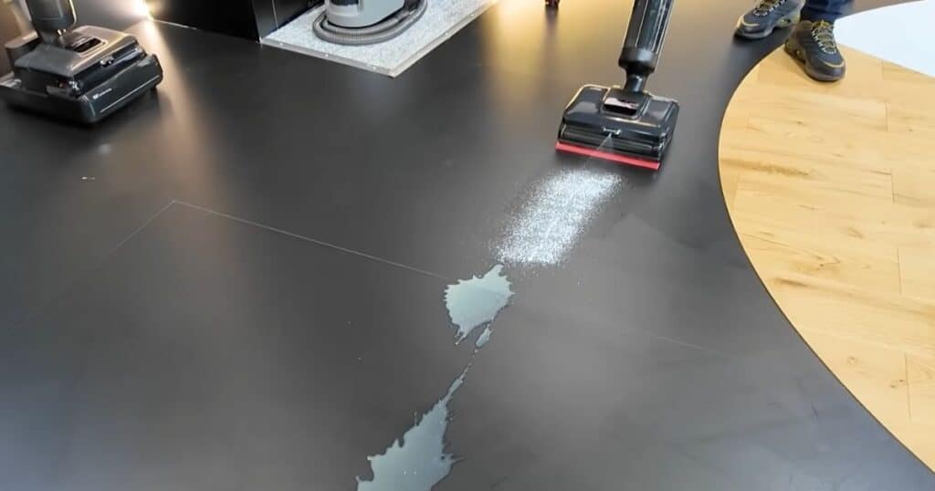 Demonstration of Dreame H15 Pro Foam Wash hard floor cleaner spraying foam onto a black surface at IFA 2025.