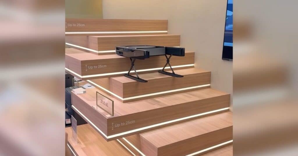 MOVA Zeus 60 stair-climbing robot vacuum module demonstrated on steps at IFA 2025, showing its ability to climb up to 25 cm.