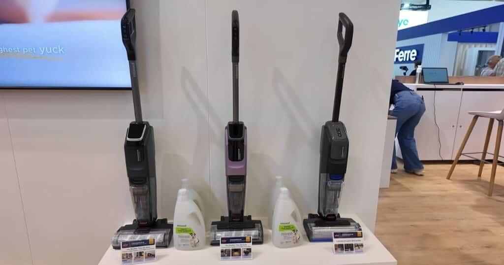 Three Bissell CrossWave models displayed side by side with cleaning solution bottles beneath them at IFA 2025 in Berlin.