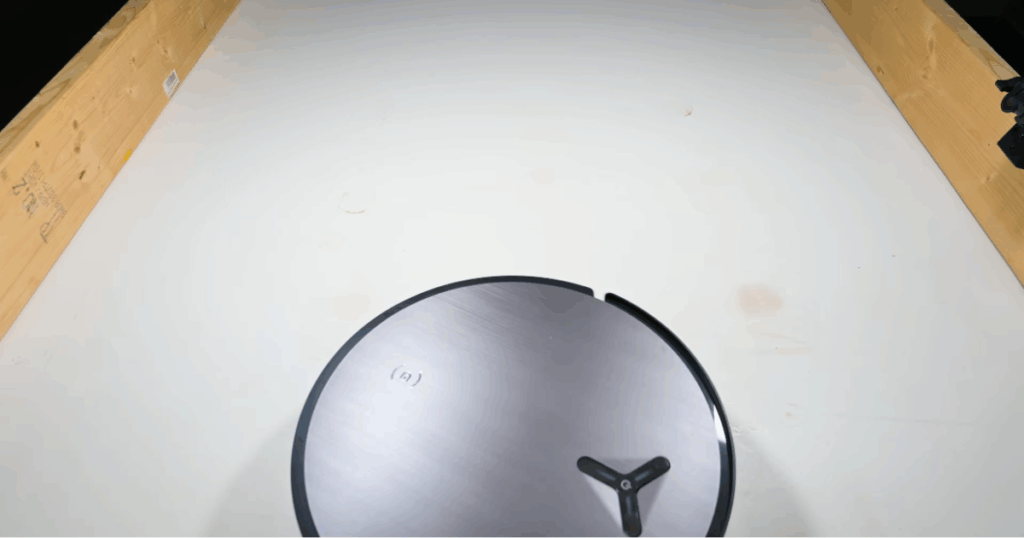 Ecovacs Deebot X11 OmniCyclone robot vacuum and mop completing mopping performance evaluations at the Vacuum Wars test studio, demonstrating its roller mop design and advanced cleaning system.