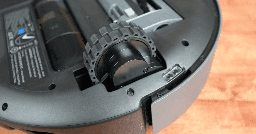 A close up of the wheels on a Eufy E20 3-in-1 robot vacuum. Robot wheels and wheel housings should be examined once or twice a month to remove any hair or grit that has gathered there