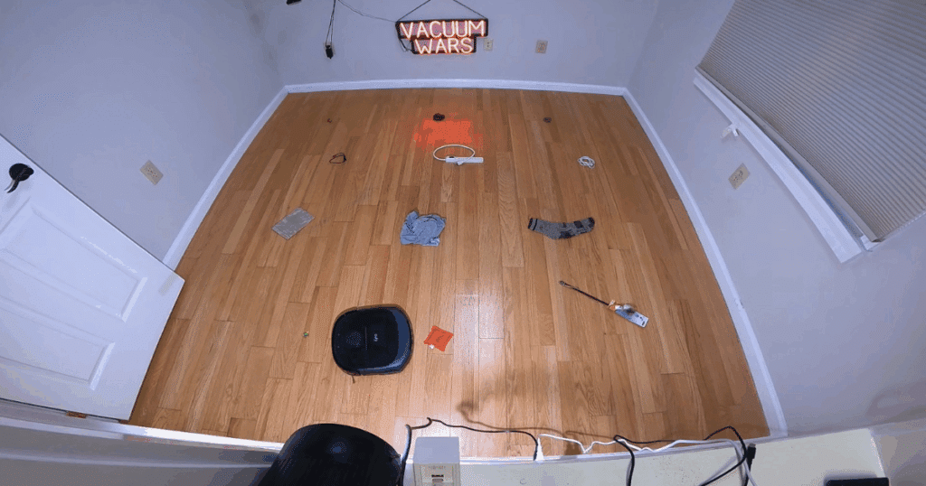 Eufy E25 Omni robot vacuum navigating around common household obstacles during the obstacle avoidance test in the Vacuum Wars studio.