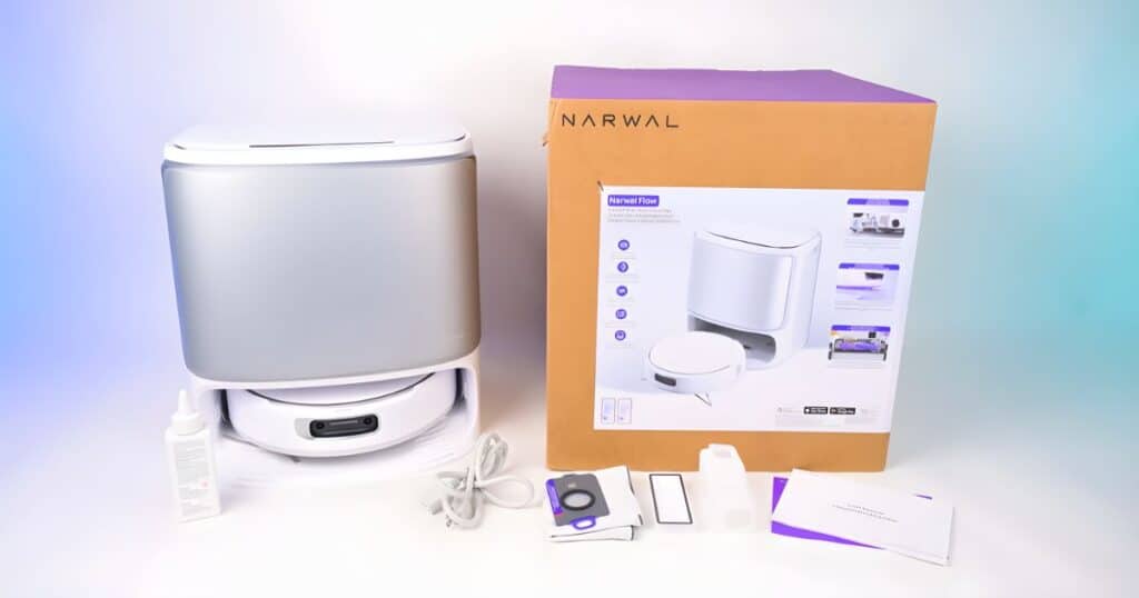 Narwal Flow robot vacuum and mop combo unboxed with base station, accessories, and packaging at the Vacuum Wars studio.