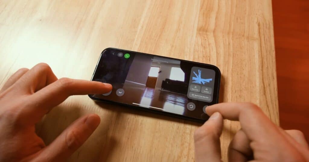 Smartphone showing Roborock app live video feed and pet search function, used for pet recognition and remote monitoring.