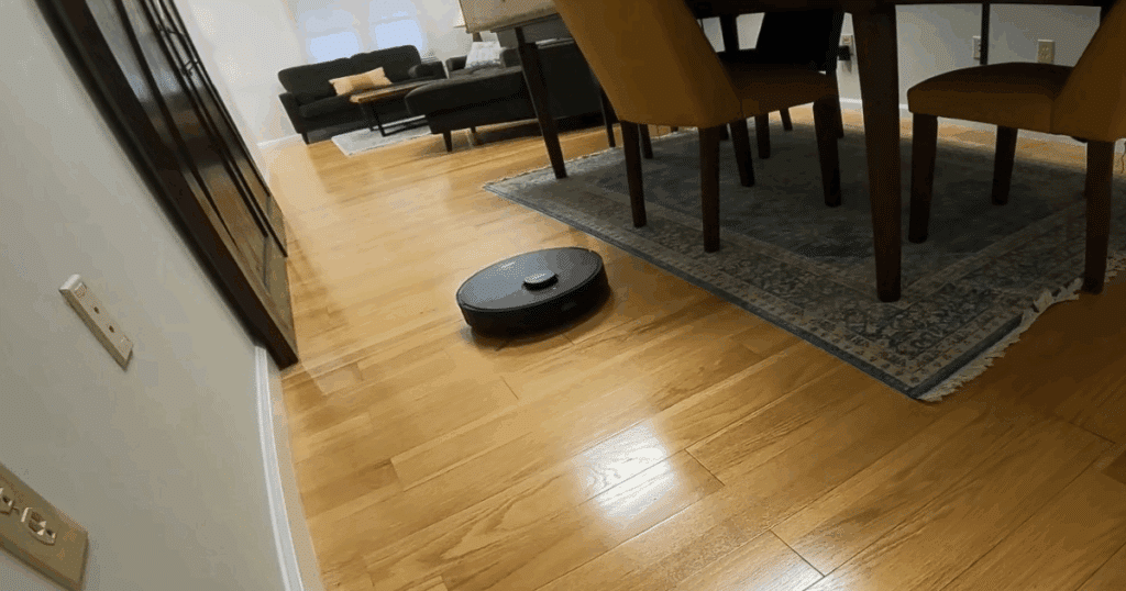 MOVA S10 robot vacuum and mop cleaning hardwood floors near a dining table and area rug