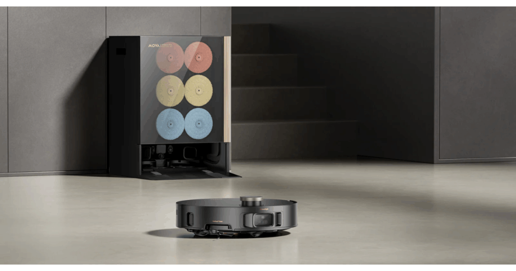 MOVA Mobius 60 robot vacuum approaching its Auto Maintenance Base Station, which stores and automatically swaps the three MopSwap pads—ThermoHold, Plush, and HyperClean—for customized mopping.