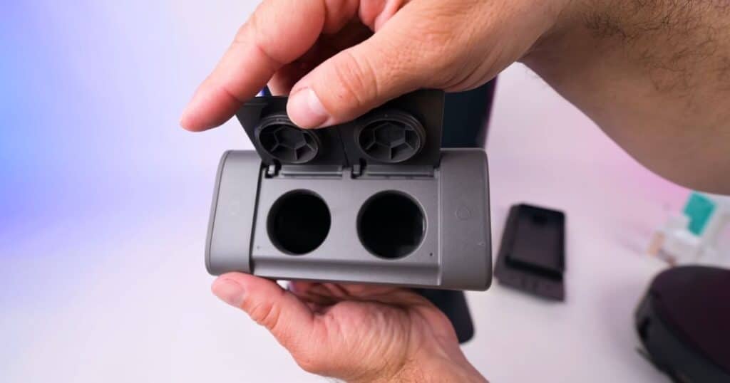 Close-up view of the MOVA Z60 Ultra Roller’s dual solution tank, showing the two refill ports with their hinged lids open and the interior compartments visible.