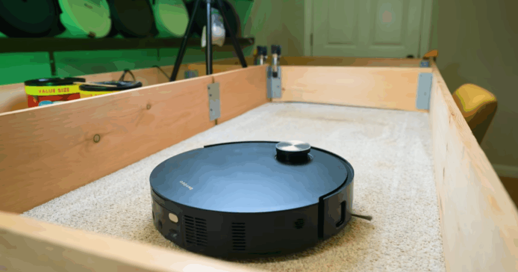 Dreame robot vacuum undergoing debris pickup testing on carpet in the Vacuum Wars evaluation setup.