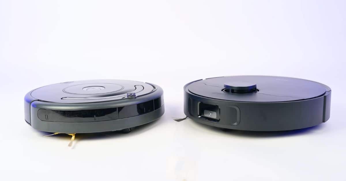 | Vacuum Wars Side-by-side studio photo of a Roomba 600 series robot vacuum on the left and the MOVA S10 robot vacuum on the right, showing the different body designs and front sensor layouts on a white background.