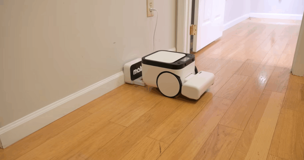 Matic charging station | Vacuum Wars Matic robot vacuum on the Vacuum Wars studio test floor next to its basic charging station, highlighting its lack of a multifunctional dock