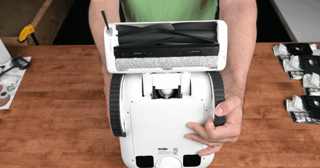 Matic robot vacuum rollers | Vacuum Wars Matic robot vacuum shown from the underside with its extended brushroll housing, main brushroll, roller-style mop pad, and motorized side brush.