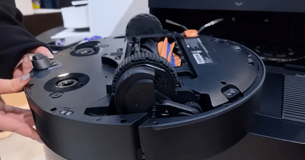 Dreame X60 Max Ultra Complete underside | Vacuum Wars Underside of the Dreame X60 Max Ultra Complete robot vacuum, showing its brush roll, wheels, and sensor layout.