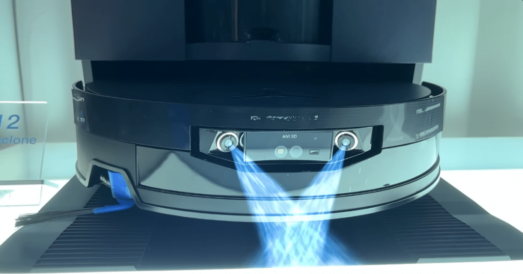 Ecovacs X12 OmniCylone Focus Jet | Vacuum Wars Close-up of the Ecovacs Deebot X12 robot vacuum demonstrating its front-mounted water spray system during a CES display.