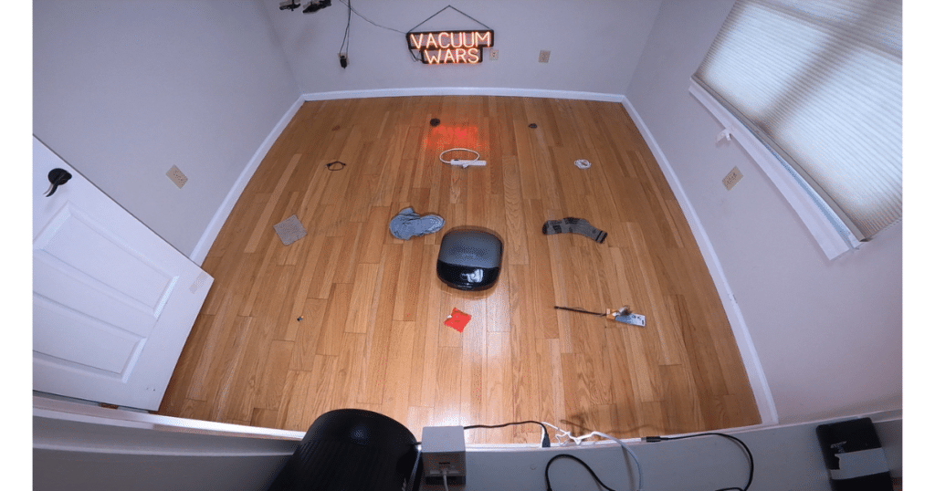 Eufy Omni S2 Robot Vacuum Obstacle Avoidance Test at Vacuum Wars | Vacuum Wars Eufy Omni S2 robot vacuum navigating the Vacuum Wars obstacle avoidance test course with household objects placed across a hardwood floor.